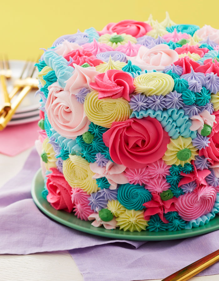 Cake with multicolored piped rosettes, dots and stars
